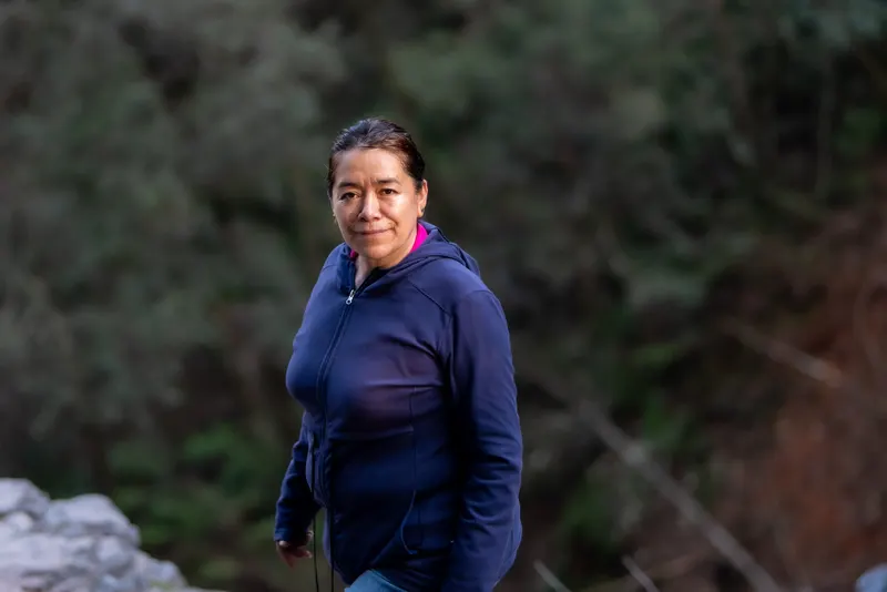 Outdoor portrait of a woman in a blue jacket on a forest trail